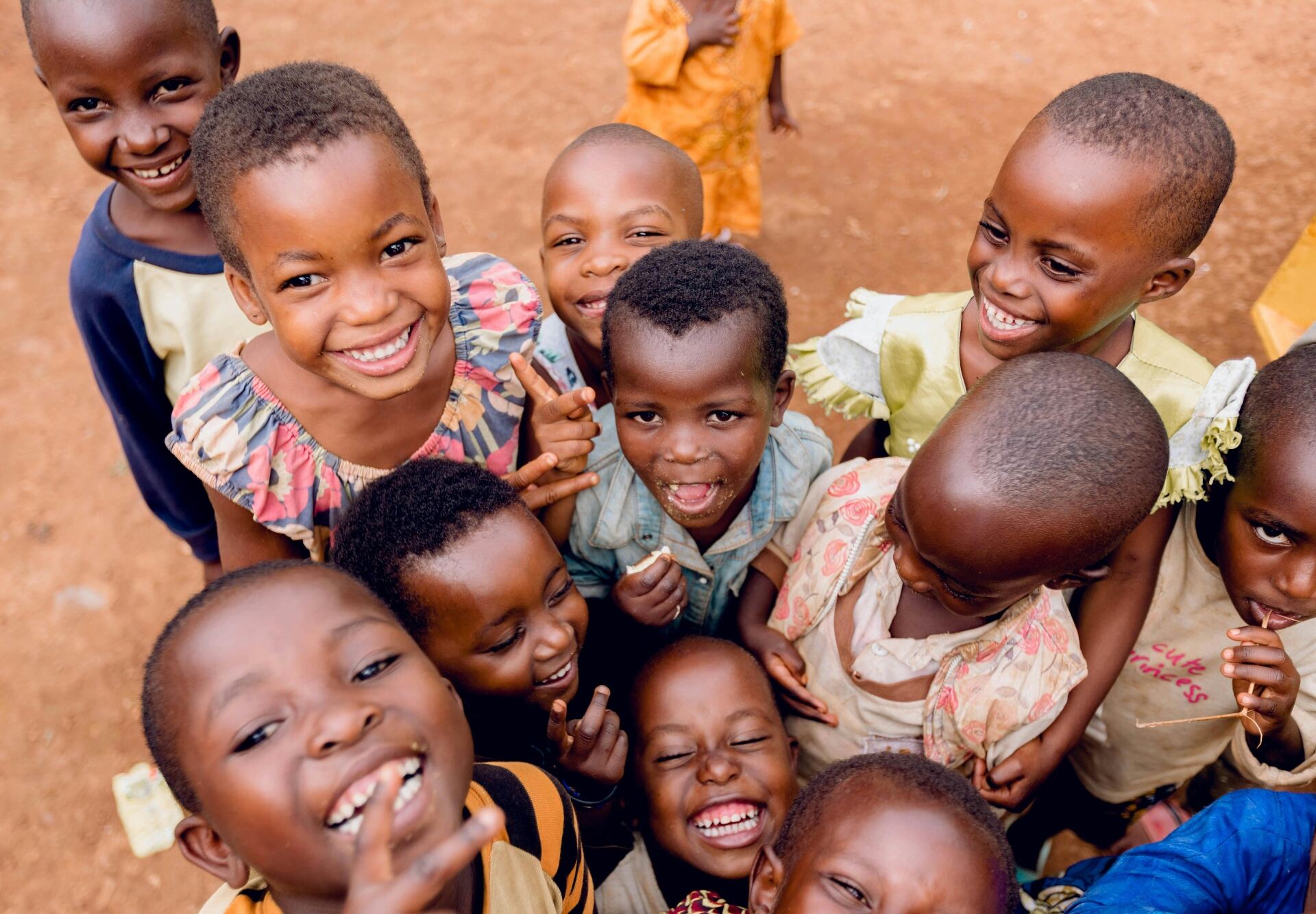 Group of joyful Kenyan children laughing together outdoors