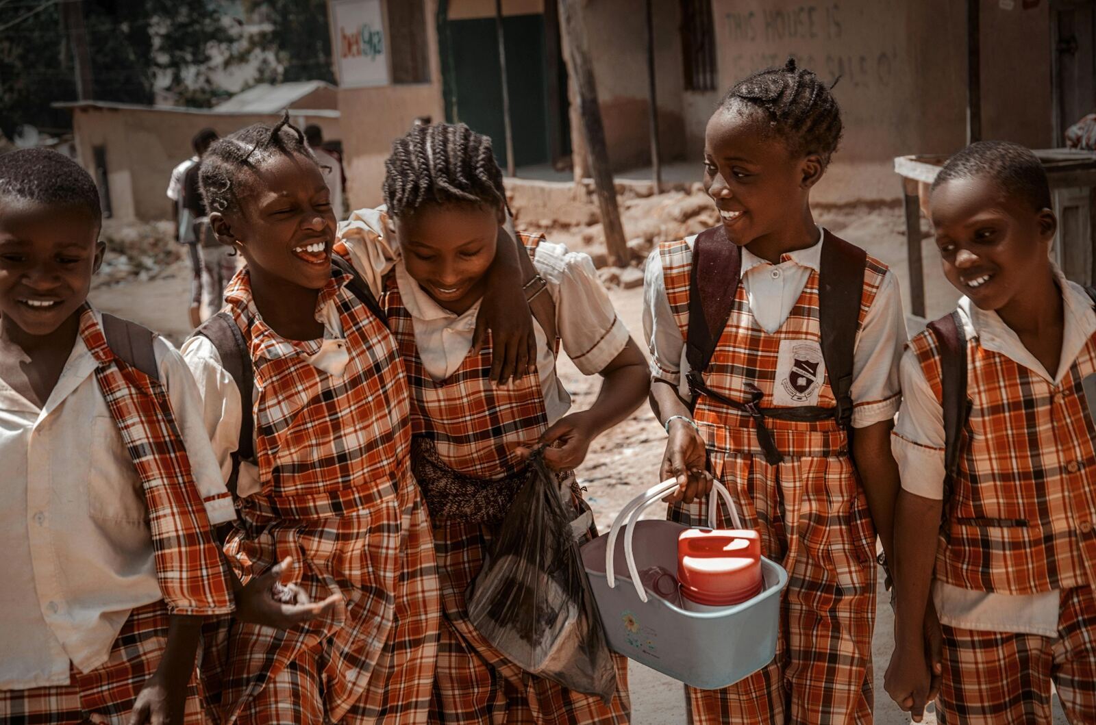 Group of African schoolgirls in uniform laughing together on the way home from school